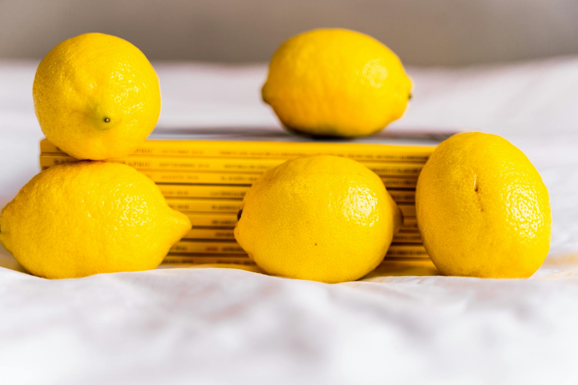 Hand holding a fresh lemon on soft pink background, symbolizing renewed sensation and pleasure